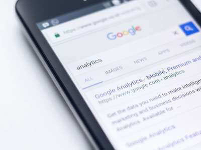 Photo of phone on Google, with search results for the keyword 'analytics'