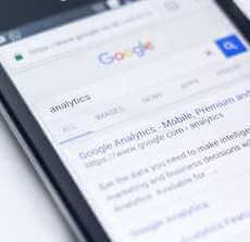 Photo of phone on Google, with search results for the keyword 'analytics'