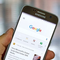 A person holding a Samsung phone and using Google search